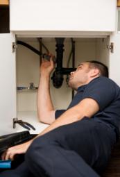  contractor examines leaky sink drain